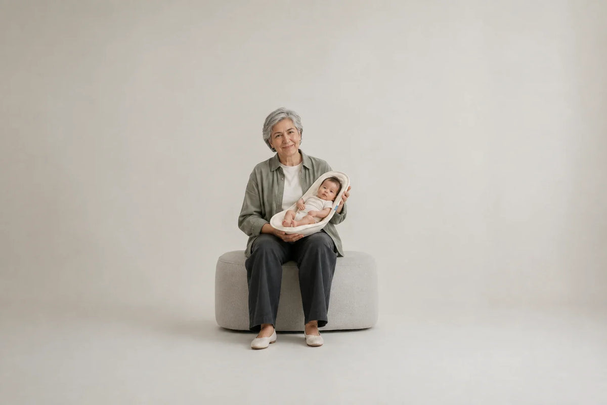 A seated grandmother supporting a baby with Nido in her arms